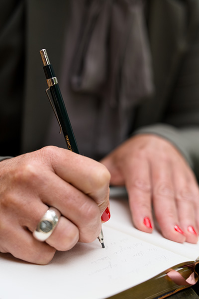Dr. Katrin Ratz schreibt einen handschriftlichen Text in ein Notizbuch.